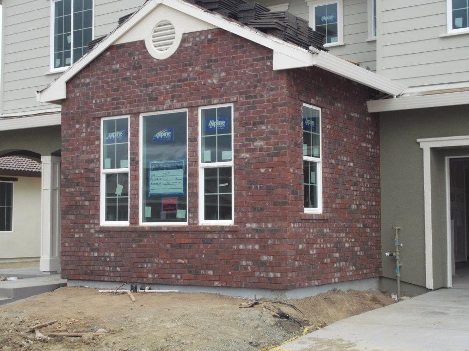 Brick facade around the windows and front gable of a house